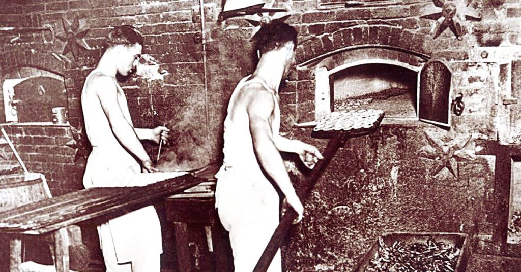 men loading pretzels into oven